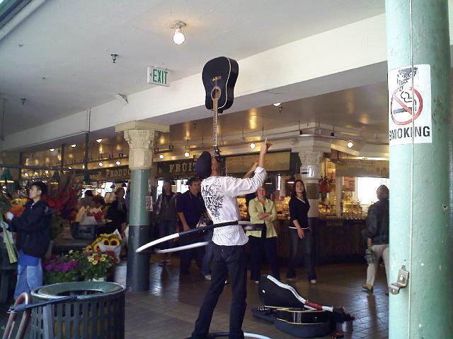 0901001256.jpg - At the market. Balancing a guitar and hula-hooping.